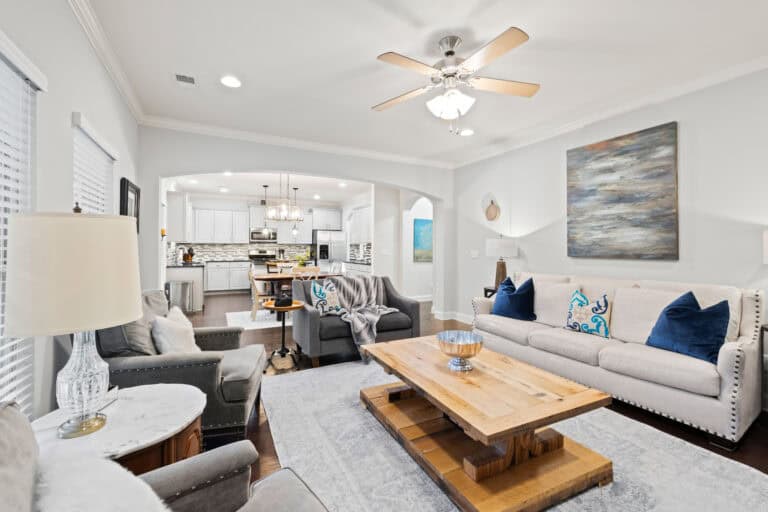 Bright, professionally staged living room and open kitchen photographed for real estate marketing.
